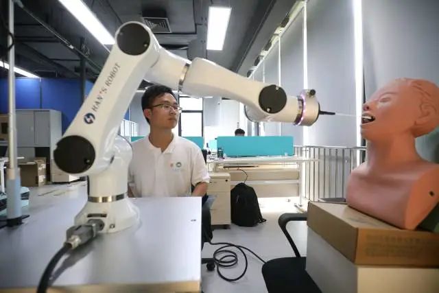 珠海澳科大科技研究院工作人員正在研究用于自動核酸采樣的機器人。 圖片