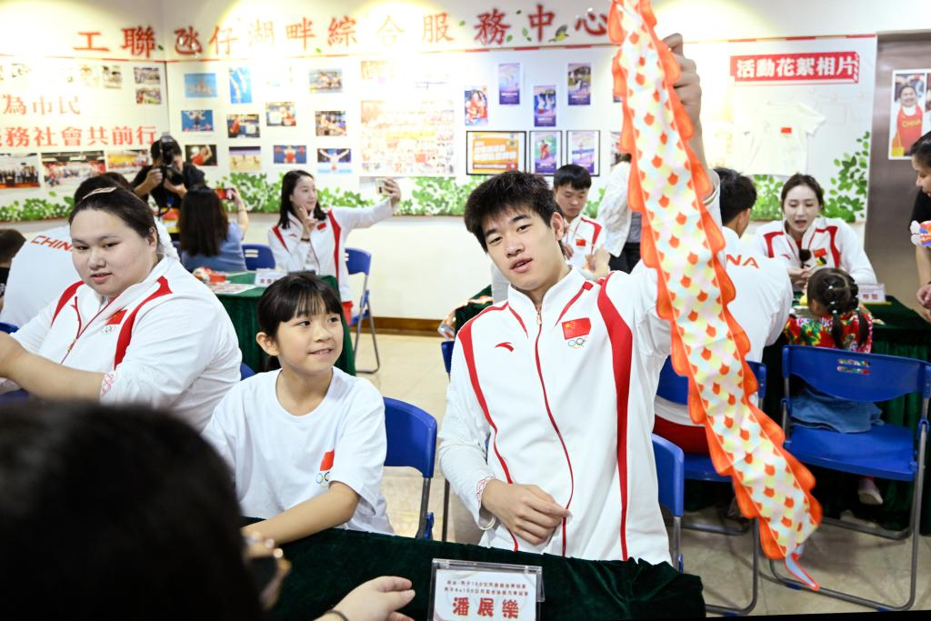 9月2日，在澳門工聯氹仔湖畔綜合服務中心，游泳運動員潘展樂（右）展示與小朋友一起制作的燈籠。當日，內地奧運健兒代表團走進澳門社區，分別到婦聯樂滿家庭服務中心、街總石排灣家庭及社區綜合服務中心和工聯氹仔湖畔綜合服務中心與市民互動。新華社發