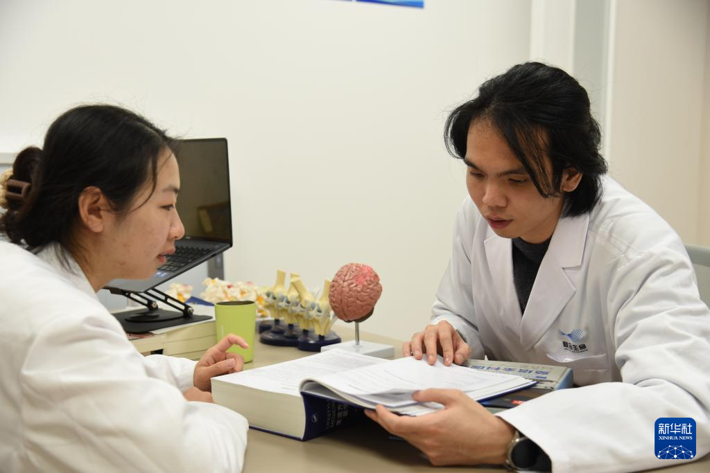 澳門醫生繆永銳(右)和同事進行交流(12月17日攝)。新華社記者 洪澤華 攝 澳門醫生繆永銳(右)和同事進行交流(12月17日攝)。新華社記者 洪澤華 攝