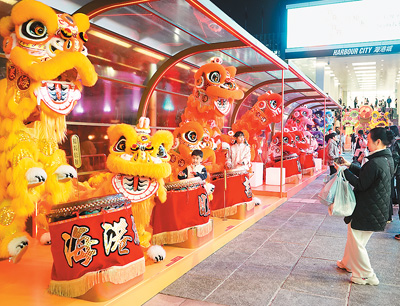 近日在香港維多利亞港畔,游客和醒獅合影。新華社記者 褚萌萌攝 近日在香港維多利亞港畔,游客和醒獅合影。新華社記者 褚萌萌攝