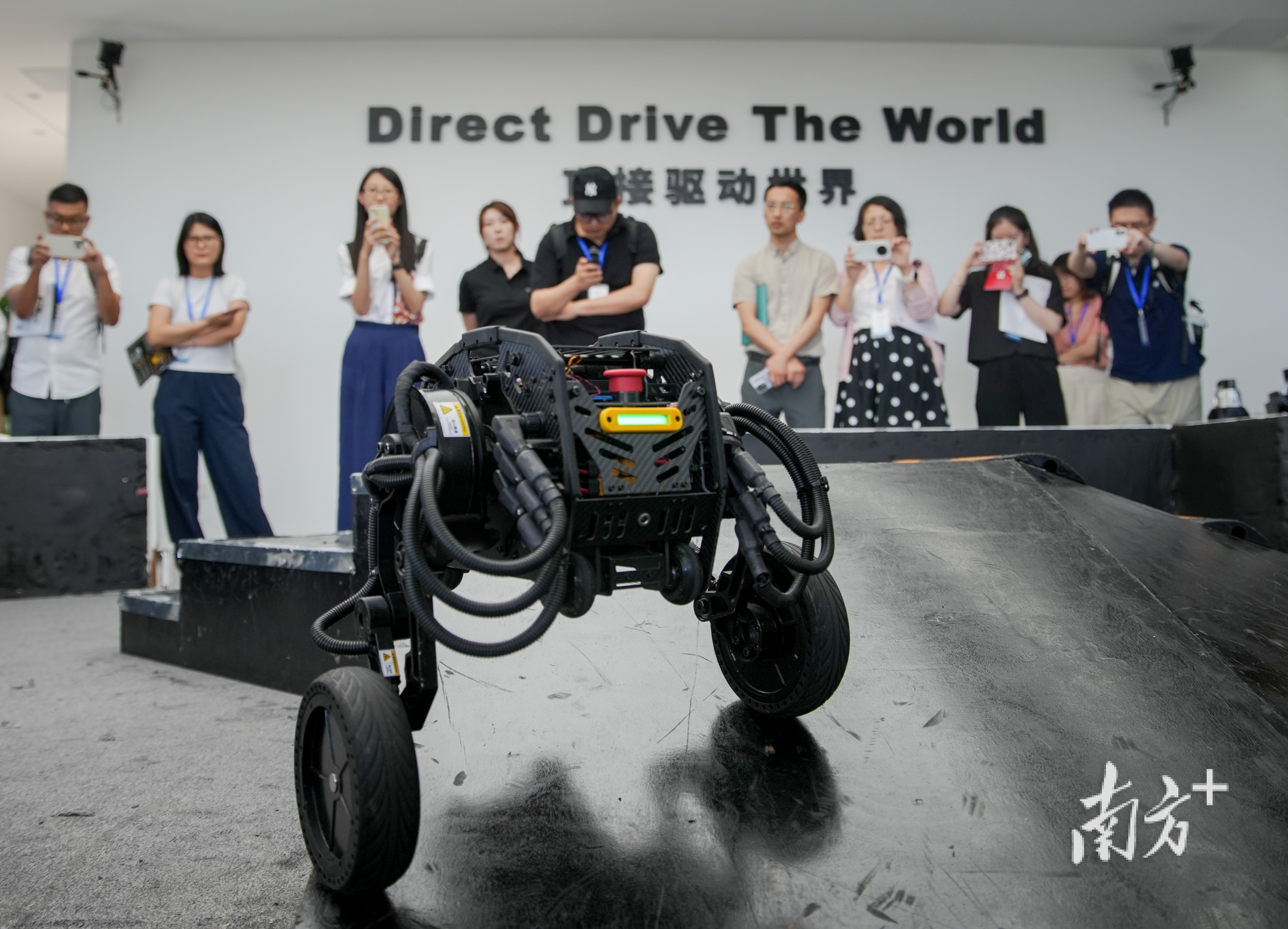 采訪團(tuán)被輪足式機(jī)器人吸引，駐足拍照。