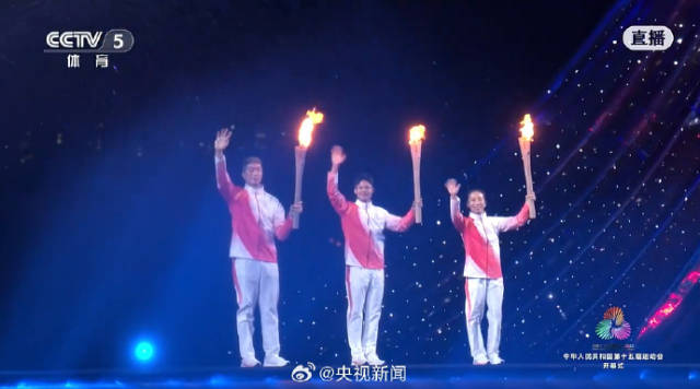  粵港澳三地火炬手蘇炳添、張家朗、李祎手持名為“綻放”火炬，一起點(diǎn)燃主火炬