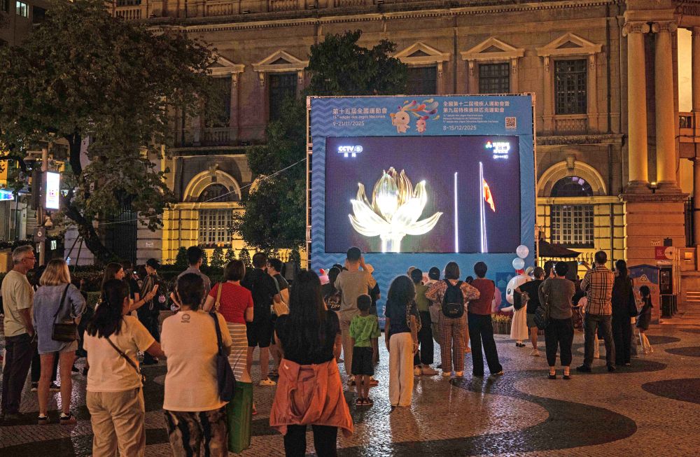 11月9日，第十五屆全國運動會開幕式在廣東奧林匹克體育中心舉行，這是群眾在澳門街頭觀看直播。新華社發（張金加 攝）