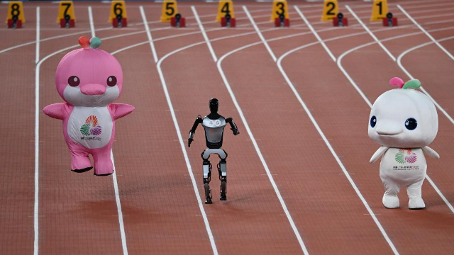 機器人和吉祥物喜洋洋、樂融融在廣東奧體中心體育場賽跑