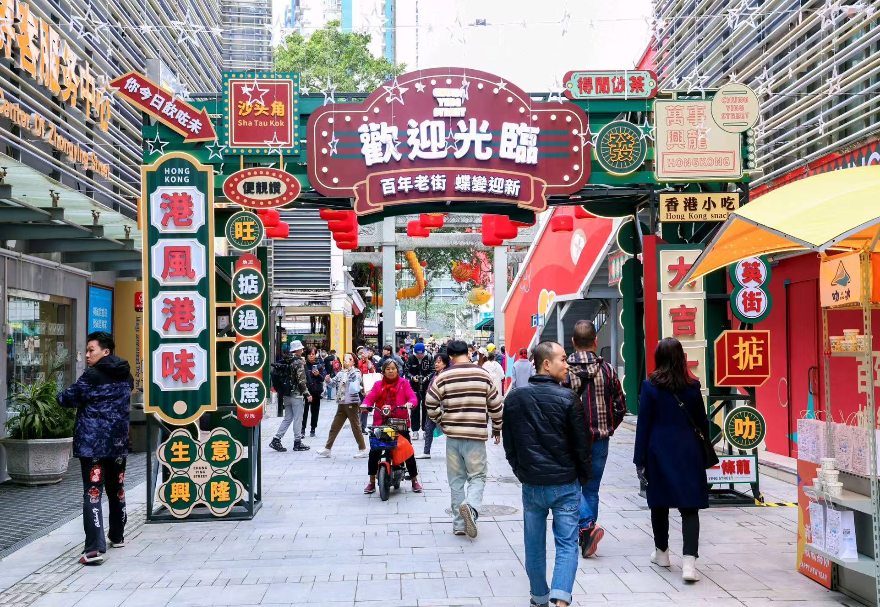 憑借毗鄰香港的獨特區位，大灣區內地城市正將港式生活美學與跨境消費體驗深度融入城市肌理，打造“港風港味”的文旅消費新場景。在沙頭角港式風情街區，建筑風貌、商鋪招牌、街頭視覺與聽覺元素高度還原了經典港式街區氛圍，匯聚國際美妝、潮流服飾、港式茶餐廳、跨境商品等特色商戶，并融入魚燈舞等非遺元素，滿足了消費者對港式風情與跨境購物的一站式體驗需求，是深港融合文化在消費領域的生動體現，成為網紅打卡與消費熱點。